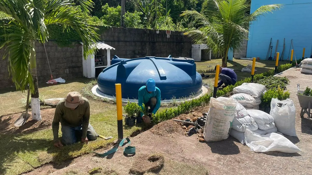Equipe da Quati assentando grama em rolo em jardim de residência