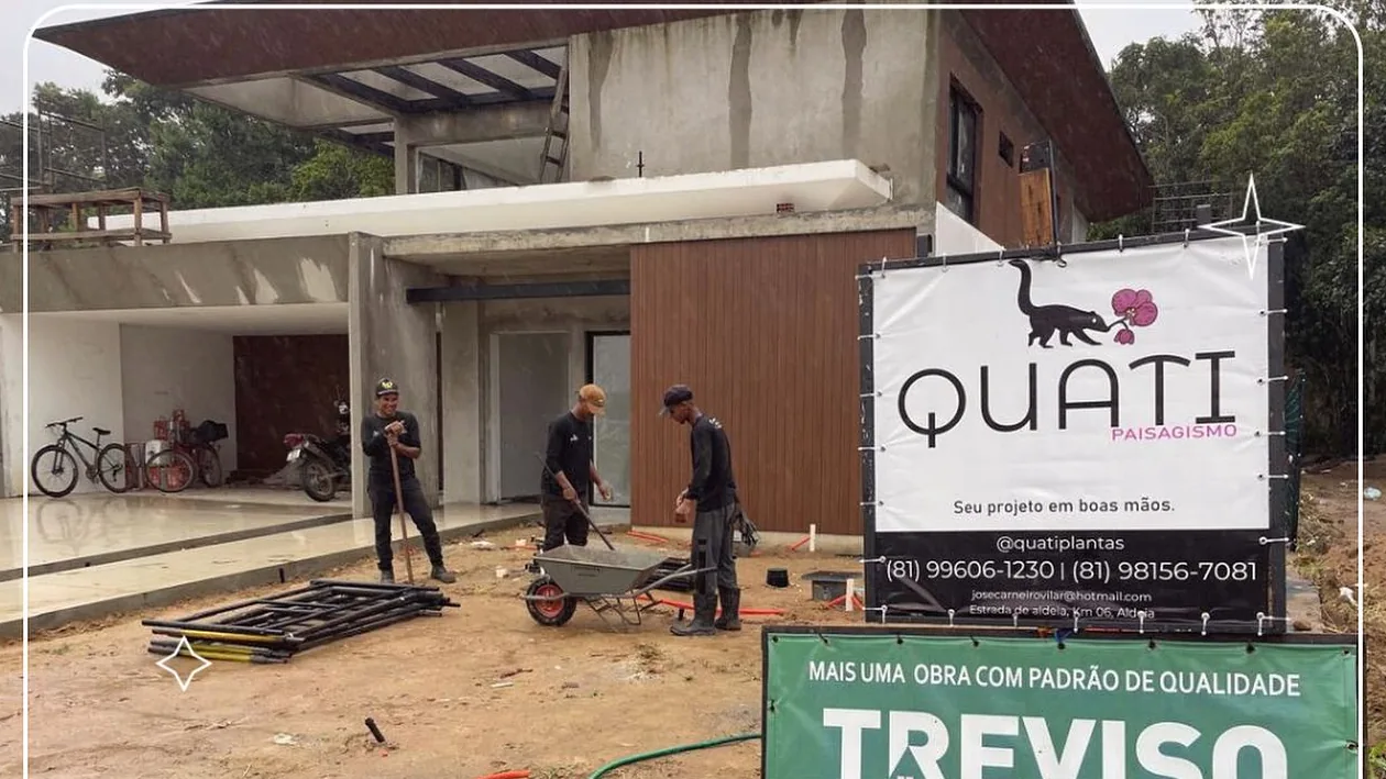 Equipe da Quati Paisagismo em obra, com o banner da empresa